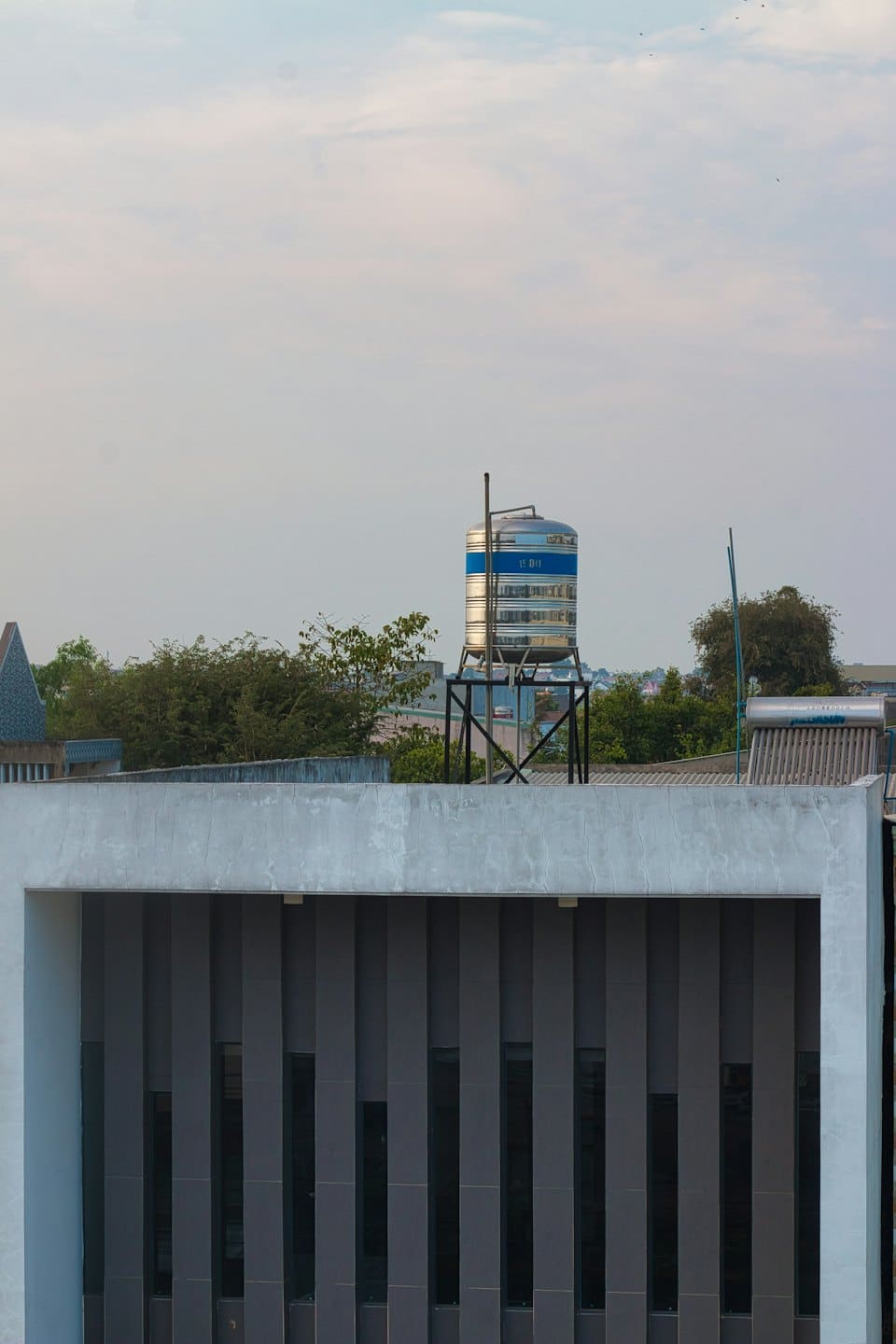 A stainless steel water tank sits on a rooftop.